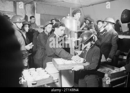 Tee und Brötchen werden 1940 von lokalen ARP-Arbeitern (Air RAID Prescautions) an ARP-Kollegen und Zivilisten in diesem Unterkellerschuft im Südosten Londons geliefert. Stockfoto