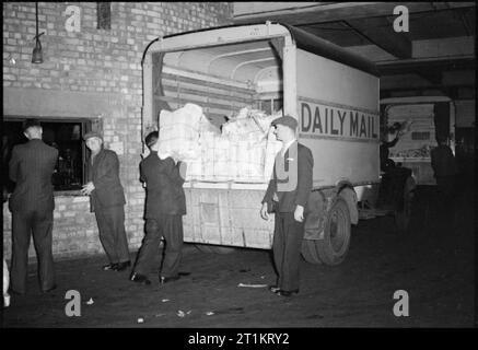 Die Voraussetzungen Eines modernen Zeitung - die Produktion der "Daily Mail" in Kriegszeiten, London, UK, 1944 Treiber laden Bündeln von Zeitungen in die Rückseite eines 'Daily Mail' van in den frühen Morgenstunden für die Lieferung an Zeitungskiosken. Die Papiere sind in alten Zeitungspapier gewickelt und mit Bindfaden. Stockfoto