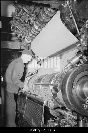 Die Voraussetzungen Eines modernen Zeitung - die Produktion der "Daily Mail" in Kriegszeiten, London, UK, 1944 eine Zeitung Mann die Walzen passt auf der Druckmaschine als Kopie der Daily Mail gedruckt wird. Beachten Sie die Buchstaben, die eingefärbt sind, und anschließend das Formular drucken auf dem Papier. Stockfoto