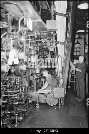 Die Voraussetzungen Eines modernen Zeitung - die Produktion der "Daily Mail" in Kriegszeiten, London, UK, 1944 Mitarbeiter bei der Arbeit an der "Lieferung" Einer der großen Druckmaschinen, die bei der Herstellung der Zeitung Daily Mail verwendet. Dieser Teil der Maschine verwendet ein komplexes System von Rollen zu falten und Zählen automatisch die Zeitungen in Lagen. Stockfoto