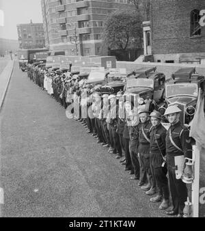 Die Rekonstruktion der 'Vorfall' - Zivilschutz Ausbildung in Fulham, London, 1942 Mitglieder der verschiedenen Zivilschutz Dienstleistungen, einschließlich Krankenwagen Arbeiter-, Rettungs- und Stretcher Parteien, Zivilschutz Aufseher und Pflegepersonal Line up mit ihren Fahrzeugen am Ende eines großen zivilen Verteidigung Training übung in Fulham. 12 Fahrzeugen und 50 Mitarbeitern, nicht einschließlich der Feuerwehr wurden in dieser Übung beteiligt. Der Vorfall Officer, trägt einen blauen Helm, steht neben seinem blauen Lampe und Flagge in den Vordergrund. Dieses Foto wurde auf Conan Street, West Cromwell Road, looki Stockfoto