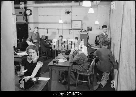 Das Telefon führt, London, Januar 1942 Ein Blick auf die Männer und Frauen bei der Arbeit in der Leitwarte. Es ist in diesem unterirdischen Raum, dass Berichte über Schäden an Pflanzen werden empfangen und aufgezeichnet. Die Vorfälle werden grafisch auf der großen Karte an der Wand (sichtbar auf der rechten Seite des Fotos) und sind dann für eine Erhebung und Reparatur von Schäden durchgeführt werden, so dass das Telefon Schaltungen so bald wie möglich wiederhergestellt werden kann. Stockfoto