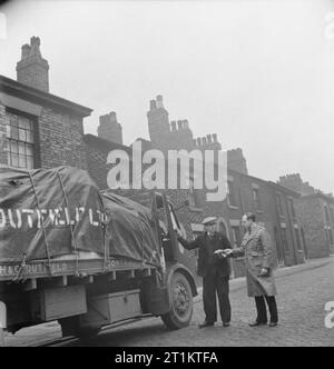 Sie Fahren bei Nacht - die Arbeit der Fernfahrer in Kriegszeiten, England, UK, 1944 um 9:30 Uhr, Lkw Fahrer Fred Horrod (links) erhält seine letzten Anweisungen von Herrn T Wolstenholme, der Manager der Manchester Depot von H&G Dutfield, vor dem Klettern in seinem Taxi für die Rückfahrt nach London. Fred hat einen Tag der Ruhe in Manchester, bevor Sie die Rückreise. Stockfoto