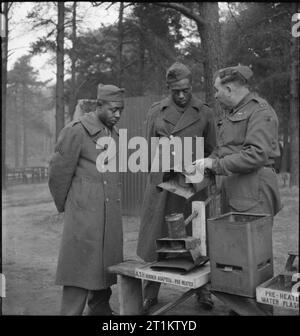 US-Truppen an der Britischen Armee Schule - amerikanische Soldaten trainieren in der Britischen Armee Schule der Hygiene, UK, 1944 als Teil der Kurs, den sie in der britischen Armee, der Schule der Hygiene teilnehmen, Private Emanuel Smith (von Lathonia, Georgien) und Corporal George S Morris (von 1007 Frank Street, Atlanta Georgia), sehen Sie sich als Mitglied der Royal Army Medical Corps zeigt eine improvisierte Öl und Wasser flash Fire. Stockfoto
