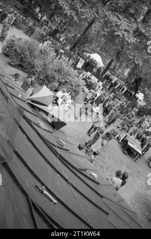 Krieg Fair - Urlaub zu Hause auf einer Fete in Russell Square, London, 1943 eine Luftaufnahme der Sehenswürdigkeiten auf dieser Messe in London Russell Square gehalten wird. Die Lautsprecher im Vordergrund werden verwendet, um die Besucher des Angebots zu informieren. In den Hintergrund, die Menschen spielen und an verschiedenen Ständen, und die Umgebung ist mit Fahnen und wimpelketten geschmückt. Stockfoto