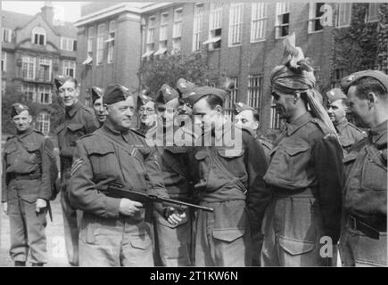 Beantworten Sie - die Produktion einer BBC Radio Programm für die Vereinigten Staaten von Amerika, Dichter 1941 Radio- und Fernsehveranstalter, FÜSILIER Z A Bokhari, ist bei der Verwendung der Tommy Gun zusammen mit seinen Kollegen in der BBC Home Guard, Bedford College ausgebildet. Bokhari hat eine besondere Erlaubnis einen Turban, statt einem feldhäcksler Kappe tragen. Stockfoto