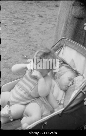 Krieg Fair - Urlaub zu Hause auf einer Fete in Russell Square, London, 1943 zwei junge, ihre Kinder im Kinderwagen schlafen, die nach einem Tag auf der Messe müde. Stockfoto