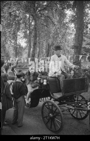 Krieg Fair - Urlaub zu Hause auf einer Fete in Russell Square, London, 1943 Zivilisten eine Fahrt rund um den Platz in einem Pferd genießen - Victoria Schlitten, gegen eine Spende für das Rote Kreuz Sammelbehälter bei einer Fete in Russell Square gehalten wird. Bunting kann im Hintergrund gesehen werden, zwischen den Bäumen. Stockfoto