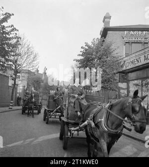 Frauen die Milch in Kriegszeiten Großbritannien liefern, 1942 Milch Mädchen verlassen das Tagebuch in ihrem Pferdewagen, die Umläufe der Milchmann, der den Service verbunden haben. Die Karren sind hoch mit Kisten gestapelt, voller Flaschen Milch. Stockfoto