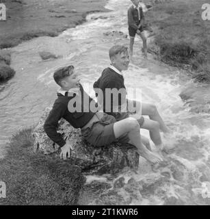 Junge Wanderer in Yorkshire - die Arbeit der Youth Hostel Association in Wartime, Malham, Yorkshire, England, Vereinigtes Königreich, 1944 Eine Gruppe von Jungen, die einen Wanderurlaub in den Yorkshire Dales machen, hält an, um ihre Füße im Wasser eines sich schnell bewegenden Baches, wahrscheinlich Gordale Beck, abzukühlen. Die Jungs wohnen in der Jugendherberge in Malham. Stockfoto