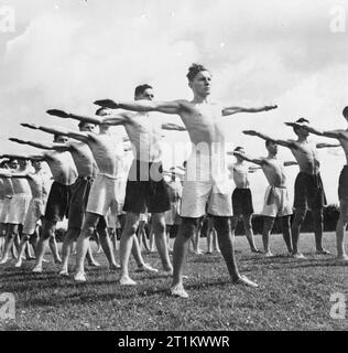 Jugendversammlungen - Ausbildung Für Jugendorganisationen, Sidcot School, Winscombe, Somerset, England, Großbritannien, 1943 Jungen demonstrieren körperliches Training während des einwöchigen Jugendtrainings in der Sidcot School in Somerset. In Reihen stehend, sind ihre Arme in der Sonne ausgestreckt. Stockfoto