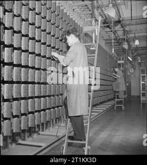Fernsprechamt - Kommunikation in Kriegszeiten, London, England, UK, 1945 Ingenieure bei der Arbeit auf dem Intermediate Distribution Frame an ein Telefon in London. Kabel kommen hier aus dem Hauptrahmen und den Austausch Gerät verbunden. Ebenso darauf achten, dass der Apparat nicht überlastet werden, dies ist auch nützlich bei der Lokalisierung von Störungen auf der Leitung. Stockfoto