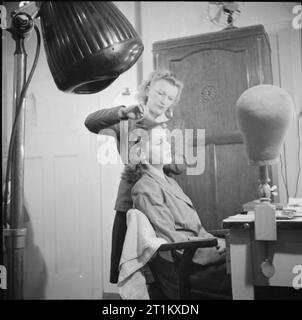 Geburt eines Sterns - Alltag für Schauspielerin Muriel Pavlow, England, UK, 1945 Friseur Elsie Bass versucht, eine andere Frisur auf Schauspielerin Muriel Pavlow in einem Ankleidezimmer, wahrscheinlich in Welwyn Garden Studios in Hertfordshire. Nach dem ursprünglichen Titel "große Aufmerksamkeit wird von Film Company zu diesem wichtigen Punkt [Frisur] gegeben. Ihre Entscheidung, die endgültig ist, nicht immer mit der Meinung der Star' zusammenfallen. Stockfoto