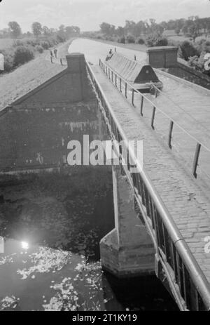 Britische Kanäle in Kriegszeiten - Verkehr in Großbritannien, 1944 ein Blick auf das Aquädukt, die die Grand Union Canal führt über den Fluss Nene in der Nähe von Wolverton, Buckinghamshire. Reisen über das Aquädukt in der Sonne kann die 'butty" von ein paar Kanal Boote gesehen werden. Kanal Boote sind meist paarweise betrieben, der Führer wird durch einen Motor, der mit dem zweiten Lauf, der "butty, hinter geschleppt. Stockfoto