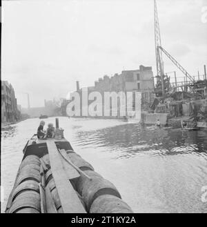 Britische Kanäle in Kriegszeiten - Verkehr in Großbritannien, 1944 zwei kleine Kinder fahren auf der 'Deck' von einem Kanal Boot Durchführung Barrel Fruchtfleisch entlang der Regent's Canal in London. Der Zellstoff wird von einem Schiff in der Themse entlang der Regent's Canal, transportiert und dann auf die Grand Union Canal bis zu den Midlands. Auf der rechten Seite des Fotos, Schäden, die durch eine frühere Air Raid klar entlang der Ufer des Canal gesehen werden kann. Stockfoto