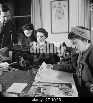 Briten lernen Türkisch - Erwachsenenbildung in London lasen 1943 britische Associate Mitglieder der Londra Turk Halkevi Kopien der türkischen Zeitschrift Cephe, um ihnen beim Studium der Sprache zu helfen. Von links nach rechts sind sie: Mr. J P Hardy, Miss Nora Bagguley, Miss K Griffin und Miss Blundell. Die meisten lernen Türkisch aus geschäftlichen Gründen. Hinter ihnen an der Mauer befindet sich ein altes Kaiserdekret, geschrieben in altrarabischer Schrift. Es wurde den Halkevi von Sultan Mahmut.Türkce präsentiert: ?Ngilizler Türkce Ö?reniyor - Londra'da Yeti?kin E?itimi, 1943Londra Türk Halkevi'nin?ngiliz Yard?mc? Üyeleri, Türk dergisi 'Ceph Stockfoto