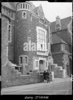 Cardiff Handelsmarine Club - Erholung und Entspannung in Cardiff, Glamourganshire, Wales, UK, c Mai 1944 Das Äußere des alten Schulgebäude, das für den Einsatz als Merchant Marine Club in Cardiff umgewandelt wurde. Ein Mann und eine Frau gesehen werden kann zu Fuß über den Eingang des Clubs. Stockfoto