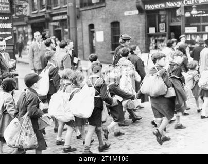 Die Evakuierung der Zivilbevölkerung Regelung in Großbritannien während des Zweiten Weltkriegs junge Kinder aus dem East End von London, die ihre Sachen, einschließlich ihrer Gasmasken, wie Sie auf Ihrer Reise in sichereren Gebieten. Stockfoto