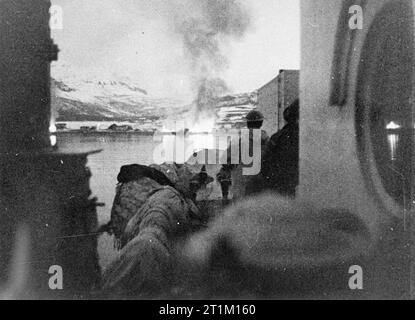 Die Royal Navy in der norwegischen Kampagne 1940 Shellbursts und Feuer am Ufer des Bjerkvik am Kopf des Herjangs Fjord, gegenüber Narvik, die von der Royal Navy am 5. Juni 1940 beschossen wurde. Stockfoto