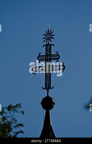Religionssymbole auf der Spitze einer Kirche in Slowenien in der Nähe des Bohinj-Sees. Doppeltes Kreuz aus Metall. Stockfoto