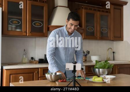 Fröhlicher Latin Koch Blogger Mann gibt Online Workshop in der Küche Stockfoto