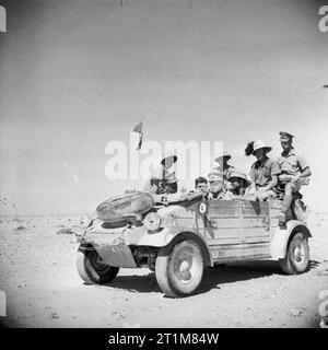 Der britischen Armee in Nordafrika 1942 italienische Kriegsgefangene zurück von den Männern der 50th Division in einem erbeuteten deutschen kubelwagen Auto begleitet, 20. Juni 1942. Stockfoto