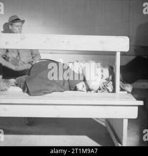 Deutschland unter alliierter Besatzung 1945 eine obdachlose deutsche Frau schlafen auf einer Bank in einem der Hamburger großen öffentlichen Luftschutzräumen. Stockfoto