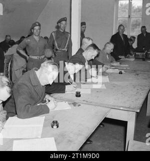 Deutschland unter alliierter Besatzung 1945 mutmaßliche Nazis füllen Sie einen Fragebogen über ihre politischen Aktivitäten in einer Haftanstalt in der Nähe von Hamburg, die von der britischen Armee. Stockfoto