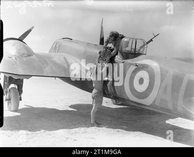 Royal Air Force Operationen im Nahen Osten und in Afrika, 1939-1943. Der Beobachter einer Bristol Blenheim Der Nr. 113 Squadron RAF Hände eine Art F. 24 antenne Kamera an ein Mitglied der Fotografischen Abteilung Ma'aten Bagush, Ägypten, nach einem Ausfall über Tobruk. Stockfoto