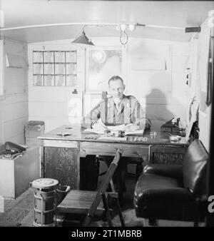 Britische Generäle 1939-1945 General Sir Miles Dempsey (1896-1969): Dempsey, Kommandant der 2. Armee, sitzt an seinem Schreibtisch in seinem Wohnwagen HQ in der Nähe von Zolder, Belgien. Stockfoto