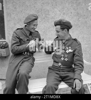 Deutschland unter alliierter Besatzung Hauptgefreiter J R Ware von Bow in London und Treiber R Rose von Pontefract mit ihrer Sammlung von NS-Medaillen in der Reichs Kanzleramt, Berlin gefunden. Stockfoto