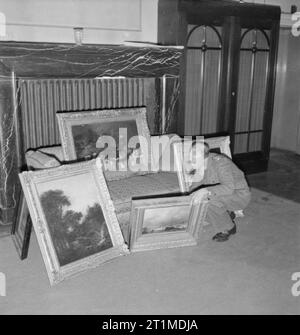 Deutschland unter alliierter Besatzung Kapitän H H Davies von Birkenhead, prüft eine Sammlung von Gemälden im Haus eines Mitglied der SS in Hannover, die Sie aus Holland geplündert hatten. Kapitän Davies war verantwortlich für die Eigenschaft, die der Dienststelle der Militärregierung, seinen Job über Nazi, Gebäuden und Eigentum, einschließlich des geraubten Kunstwerke. Letztere zur sicheren Aufbewahrung bis zu ihren rechtmäßigen Besitzern zurück gehalten wurden. Stockfoto