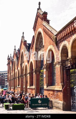 Die Menschen trinken in der Sonne vor dem alten Wholesale Fish Market im Northern Quarter, Manchester Stockfoto