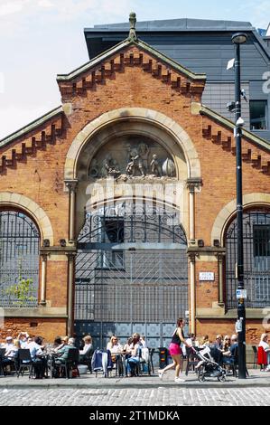 Die Menschen trinken in der Sonne vor dem alten Wholesale Fish Market im Northern Quarter, Manchester Stockfoto