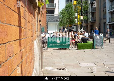 Die Menschen trinken in der Sonne vor dem alten Wholesale Fish Market im Northern Quarter, Manchester Stockfoto