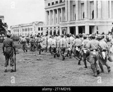 Britische Wiederbesetzung von Singapur, 1945 Japanische Kriegsgefangene genommen werden im Double in Singapur, wo sie getätigt wurden, um die Stadt zu löschen. Stockfoto