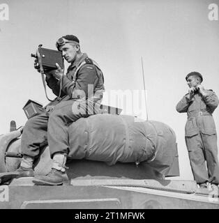 Die polnische Armee in der Normandie Kampagne 1944 Kameraleute in Uniform: 2nd Lieutenant Jerzy Januszajtis, einer polnischen Armee Film Unit Kameramann, Filme von der Spitze eines Sherman Panzer der 1. polnischen Panzerdivision in Tank während der Operation 'Totalisieren', südlich von Caen, Normandie am 8. August 1944. Er ist mit einem DE Vry Kamera mit einer Schlinge versehen. Stockfoto