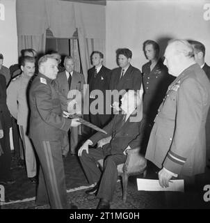 Die Konferenz von Teheran, Iran, 28. November bis 1. Dezember 1943 Marschall Kliment Woroschilow zeigt das Stalingrad Schwert von US-Präsident Franklin D Roosevelt im Konferenzraum auf dem sowjetischen Gesandtschaft in Teheran, Iran, der am 28. November 1943 während der Premierminister Winston Churchill und Marschall Joseph Stalin. Stockfoto