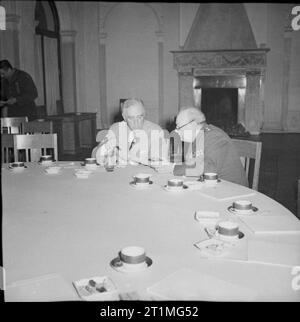 Die Konferenz von Jalta, Februar 1945 Präsident Roosevelt und Winston Churchill sind tief in der Diskussion, wie Sie an den großen runden Tisch im Konferenzraum sitzen, nach dem Treffen. Leere Kaffeetassen können auf dem Tisch gesehen werden. Die anderen Delegierten auf der Konferenz haben den Raum verließ. Stockfoto