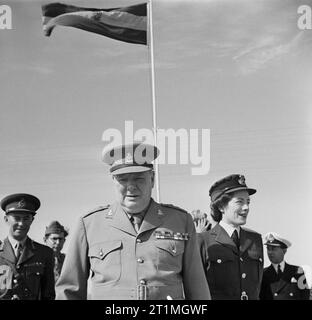 Winston Churchill mit seiner Tochter Sarah, bei einem Besuch in seinem alten Regiment, der 4 Queen eigene Husaren, in Ägypten, vom 5. Dezember 1943. Der Premierminister Winston Churchill trägt die Uniform eines vollen Oberst des 4. Queen eigene Husaren unter der regimental Flag mit seiner Tochter, Sarah, und Generalleutnant Stein bei seinem Besuch in das Regiment am 5. Dezember 1943. Stockfoto