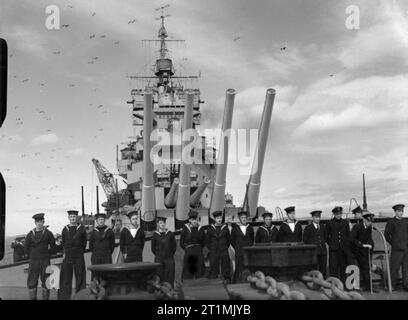 Die Royal Navy während des Zweiten Weltkriegs von der focsle in Richtung der 6, 14-Zoll-Kanonen von HMS Howe, mit den Waffen auf maximale Höhe und eine Gruppe von Matrosen vor Ihnen auf. Stockfoto