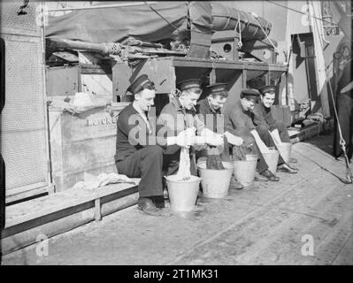 Die Royal Navy während des Zweiten Weltkrieges einige der Crew saß in einer Linie ihrer Waschmaschine in Eimern auf dem Deck der HMS EITELKEIT während der Zerstörer ist auf escort Pflicht. Stockfoto