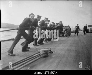 Die Royal Navy während des Zweiten Weltkriegs Matrosen haul entfernt auf einer Der abspannseile der wichtigsten Derrick an Bord der HMS Rodney. Stockfoto