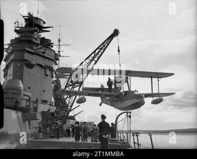 Die Royal Navy während des Zweiten Weltkriegs Absenken des Schiffes Supermarine Walrus Flugzeuge für einen Aufklärungsflug an Bord des britischen Schlachtschiff HMS Rodney. Stockfoto