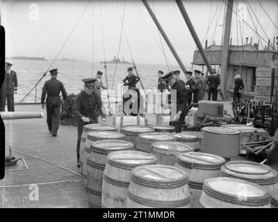 Die Royal Navy während des Zweiten Weltkrieges die Bereitstellung eines NELSON klasse Schlachtschiff, wahrscheinlich HMS Rodney und Vorräte für drei Monate. Royal Marines prüfen Sie die speichert, wie sie an Bord gebracht werden. Die Fässer enthalten Geschirr. Die Brücke des Schiffes kann im Hintergrund gesehen werden. Das Schlachtschiff durchgeführt eine Crew von über 1300. Stockfoto