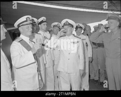 Die Royal Navy während des Zweiten Weltkriegs Admiral Nimitz (links), Admiral Sir Bruce Fraser und General Spaatz ein Rum mit dem Schiff Unternehmen von HMS DUKE OF YORK nehmen. W Admiral Chester Nimitz, Oberbefehlshaber der Alliierten Seestreitkräfte im Pazifik, hat die Reihenfolge der Knight Grand Cross des Bades, einer der höchsten Bestellungen im Britischen Empire. Admiral Sir Bruce Fraser, Oberbefehlshaber der britischen Pazifikflotte, in Vertretung Seiner Majestät König George VI, die Dekoration an Bord der sein Flaggschiff HMS DUKE OF YORK in Guam verliehen. Stockfoto