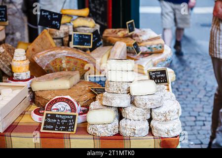 Käsestand und Ausstellung lokaler handwerklicher Käsesorten auf einem Außenmarkt in Annecy, Frankreich, mit einer großen Auswahl an Hart- und Weichkäsesorten Stockfoto