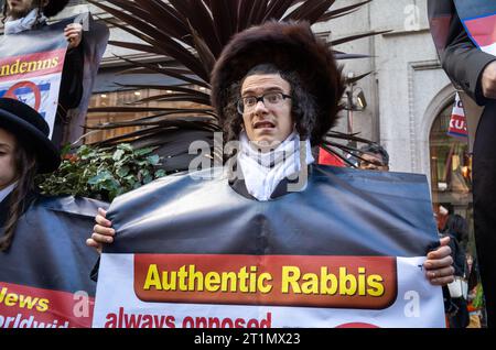 London, Großbritannien. 14. Oktober 2023: Ein junger Mann aus der jüdischen Gruppe Neturei Karta, oder Wächter der Stadt, protestiert für Palästina und gegen israelische Angriffe auf Gaza. Auf dem Plakat steht: „Juden für ein freies Palästina“ Stockfoto