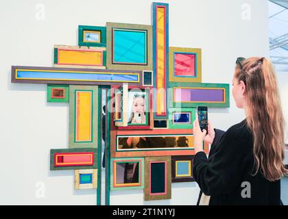 London, Großbritannien. Oktober 2023. Ein Besucher und Reflexion mit dem zeitgenössischen chinesischen Künstler Song Dong, 'Nützlichkeit der Nutzlosigkeit - variiertes Fenster Nr. 23', 2020 im Pace Gallery Space. Die Frieze London, eine der einflussreichsten Messen für zeitgenössische Kunst, zieht weiterhin Besucher und Kunstkäufer an. Die Ausgabe 2023 feiert den 20. Jahrestag der Frieze London. Sie läuft am 11-15. Oktober 2023 im Regent's Park. Quelle: Imageplotter/Alamy Live News Stockfoto