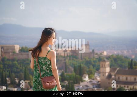 Eine Frau, die auf dem Berggipfel steht und über die Alhambra blickt, Granada, Spanien Stockfoto